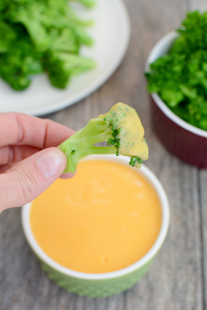 steamed broccoli dipped in simple cheese sauce