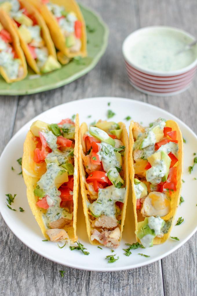 These gluten-free Baked Chicken Tacos with Creamy Cilantro Sauce will quickly become a favorite family dinner recipe! 