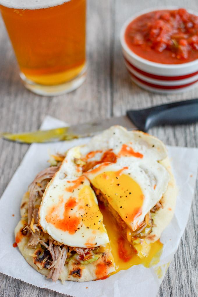 This Pork and Egg Breakfast Pizza is perfect for a late morning football party or tailgating. Cook the pork overnight, then just shred, assemble and top with an egg!