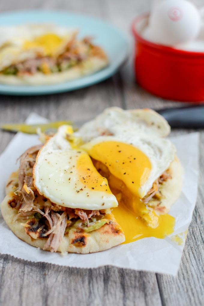 This Pork and Egg Breakfast Pizza is perfect for a late morning football party or tailgating. Cook the pork overnight, then just shred, assemble and top with an egg!