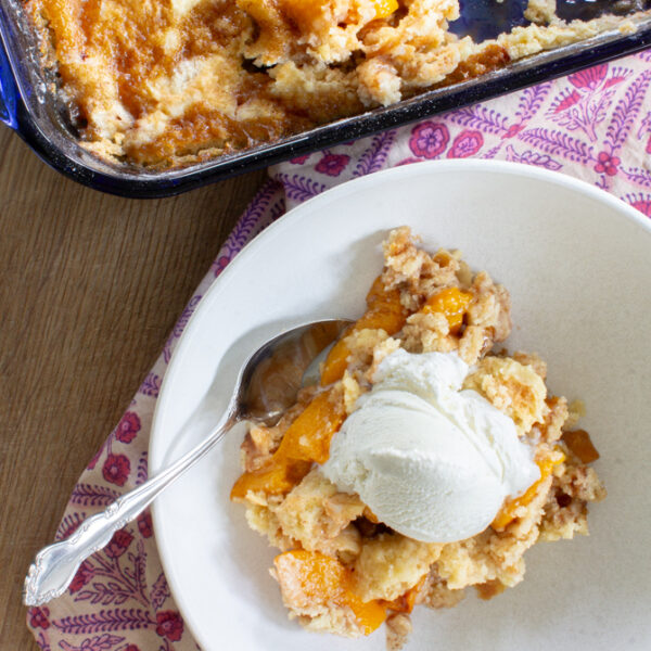easy peach cobbler dump cake with vanilla ice cream